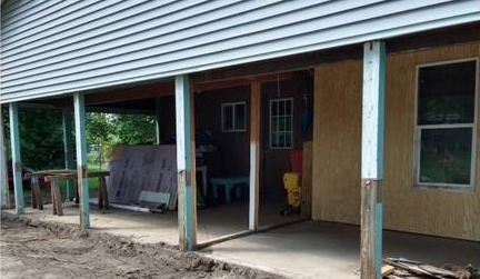 Open porch with old posts on a Caledonia, Michigan home before siding and window replacement